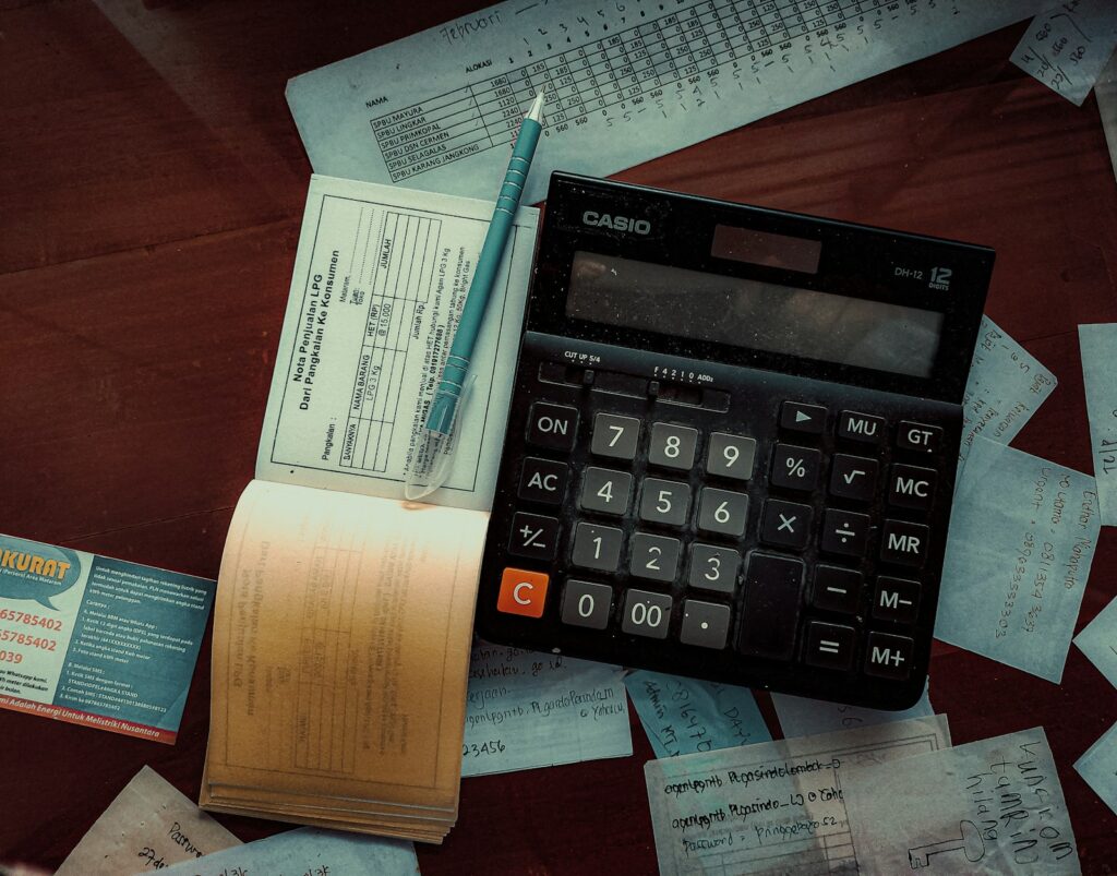 Calculatrice Casio posée sur un bureau au milieu de factures et de reçus manuscrits